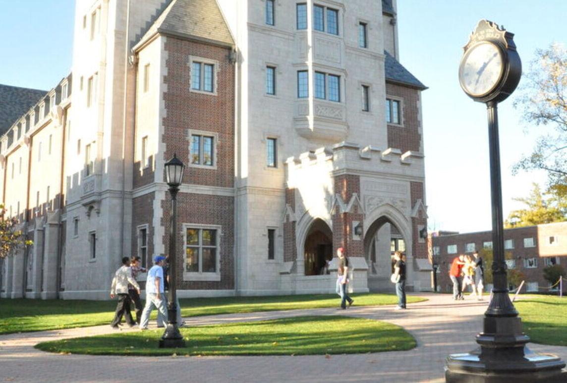 Students walk in front of Meier Hall on a fall day